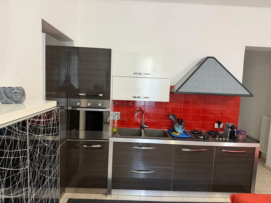 Cucina attrezzata con forno, frigorifero, piano cottura e lavello