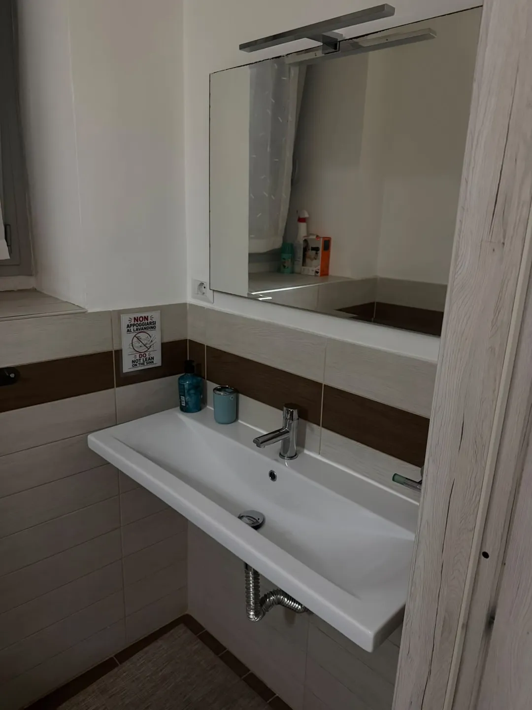 Lavabo del bagno con specchiera e illuminazione